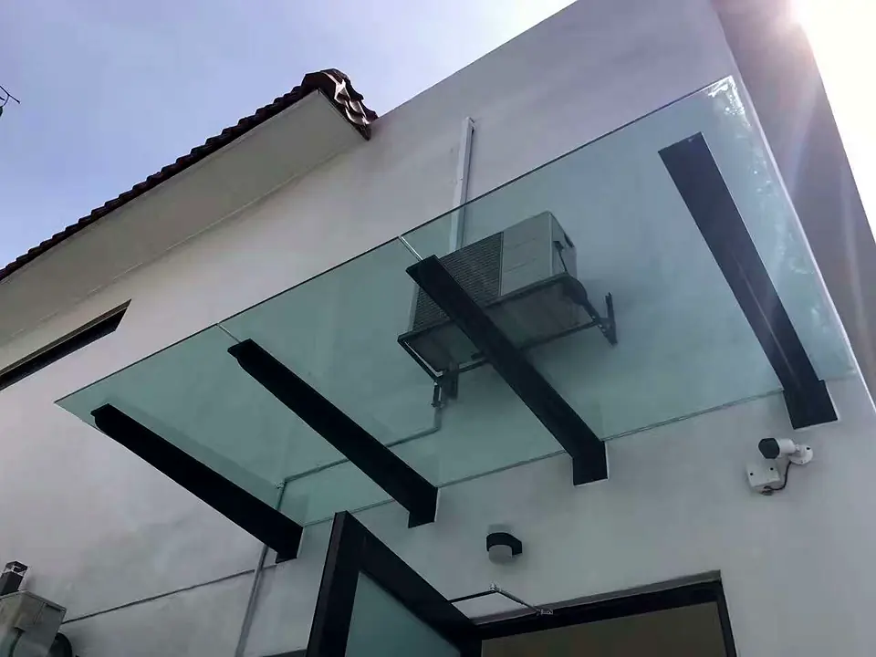 Frameless glass awning on black steel brackets