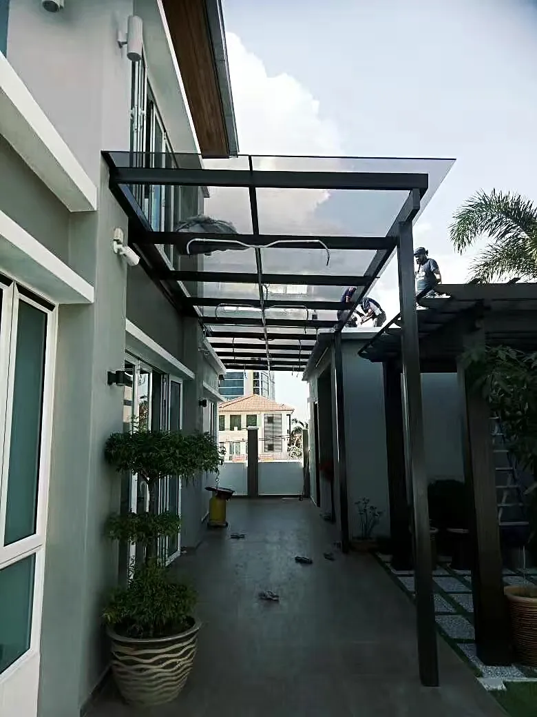 Glass canopy on steel posts over a side walkway