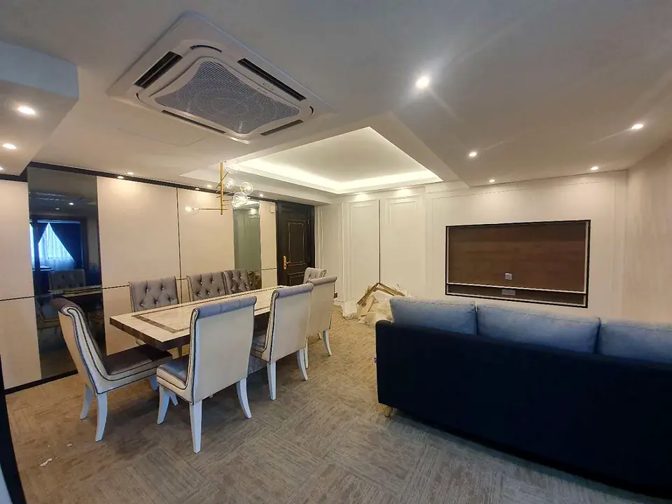 Living and dining room under a cove-lit ceiling
