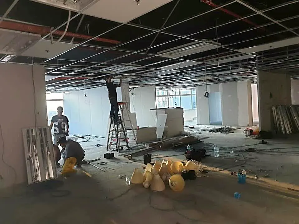 Before: an office floor stripped back, with the ceiling opened up